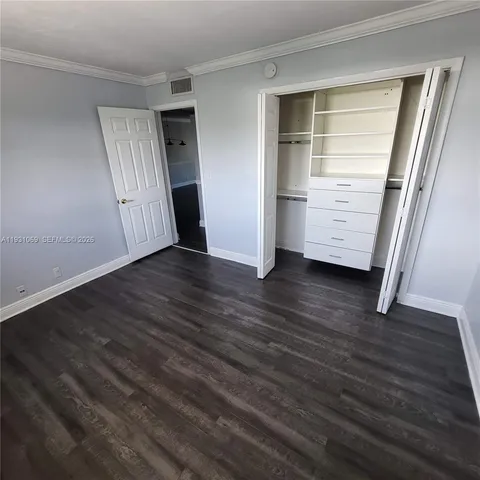 an empty room with wooden floor and closet