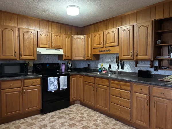 a kitchen with stainless steel appliances granite countertop a refrigerator a oven a sink and dishwasher