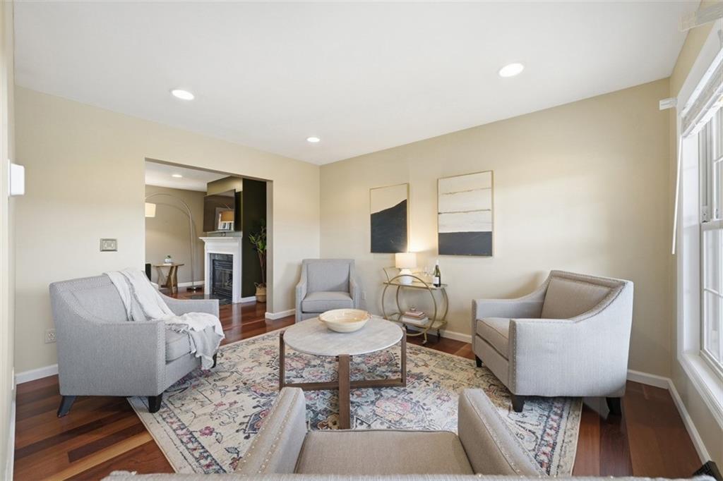 Filled with natural light, the front living room offers flexible space for a home office, reading lounge, playroom, or additional gathering area depending on your lifestyle needs. Warm hardwood flooring and neutral tones create an inviting, easy-to-personalize atmosphere.