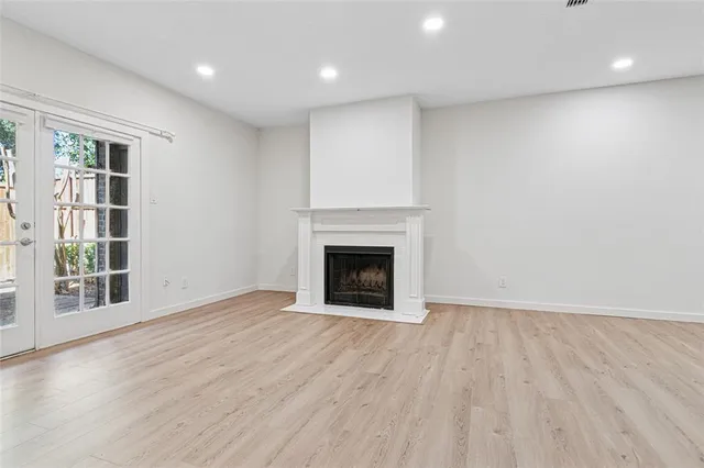 an empty room with wooden floor and fireplace