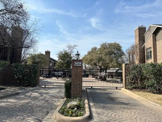 a sign board with buildings in the background