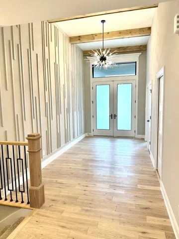 a view of a hallway with wooden floor and staircase
