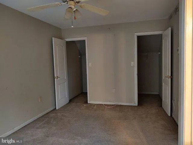 a view of an empty room with a ceiling fan