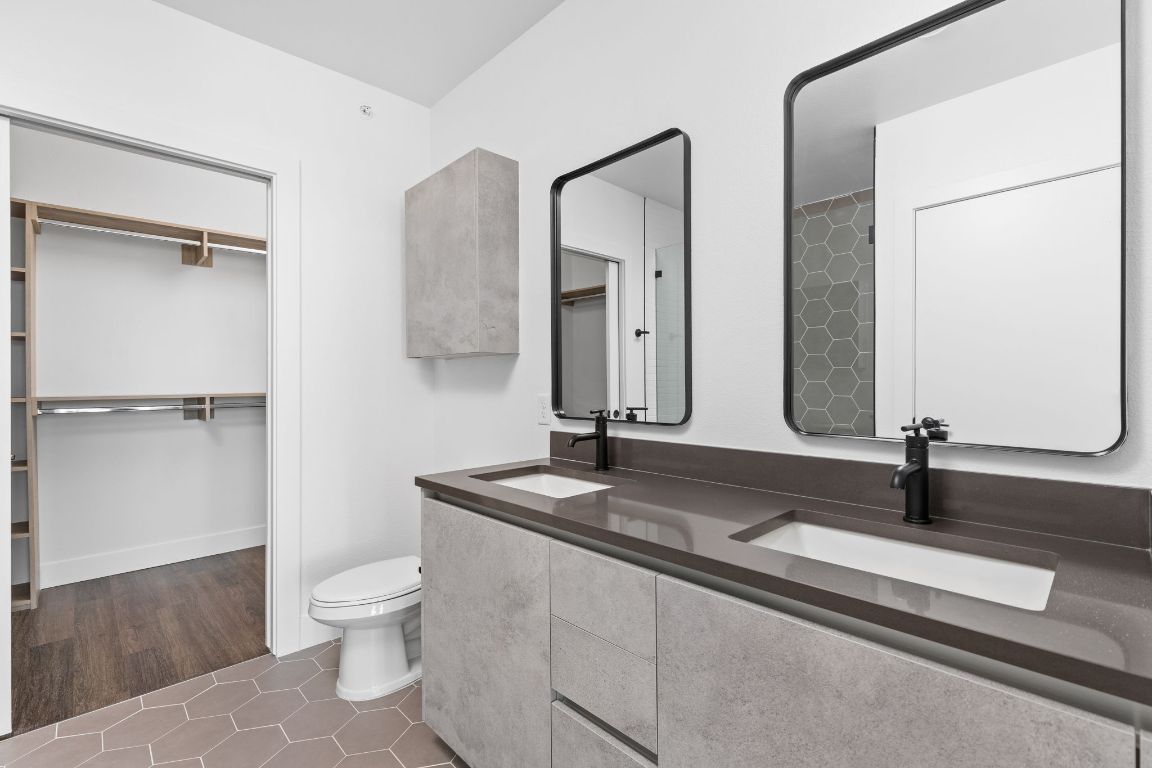 4315 South Congress Avenue, Unit 527 Austin, TX 78745 - Photo 15 of 37 a bathroom with a double vanity sink toilet and mirror
