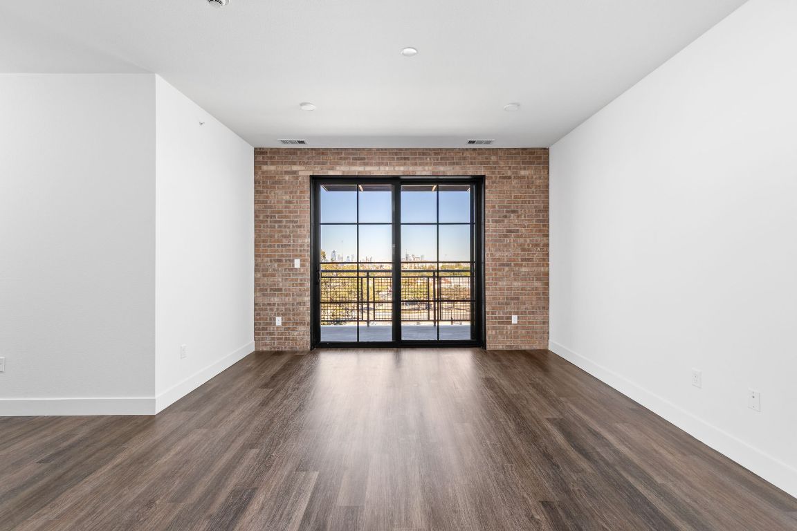 4315 South Congress Avenue, Unit 527 Austin, TX 78745 - Photo 2 of 37 an empty room with wooden floor and windows