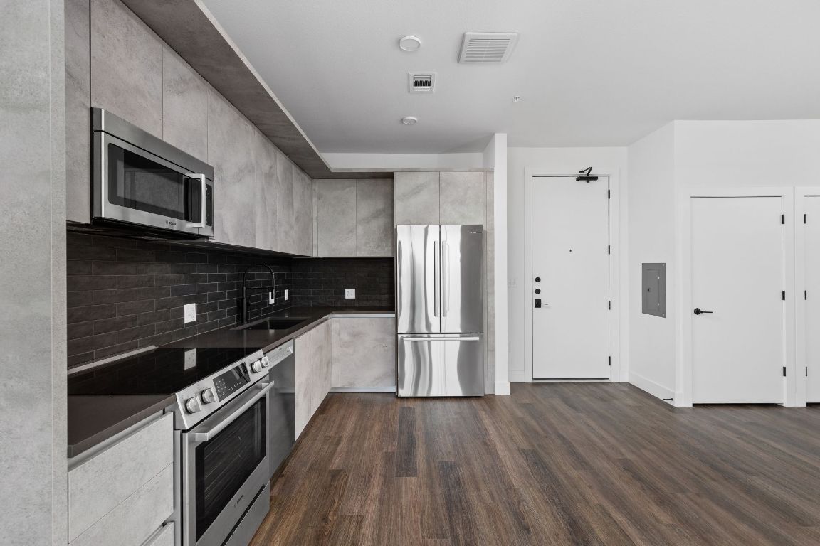 4315 South Congress Avenue, Unit 527 Austin, TX 78745 - Photo 6 of 37 a kitchen with stainless steel appliances a refrigerator and a stove top oven