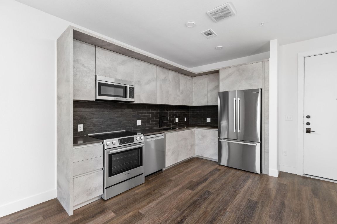 4315 South Congress Avenue, Unit 527 Austin, TX 78745 - Photo 7 of 37 a kitchen with stainless steel appliances a refrigerator sink and microwave
