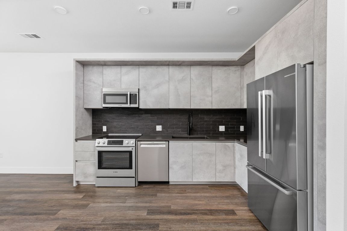 4315 South Congress Avenue, Unit 527 Austin, TX 78745 - Photo 8 of 37 a kitchen with stainless steel appliances granite countertop a refrigerator and a stove
