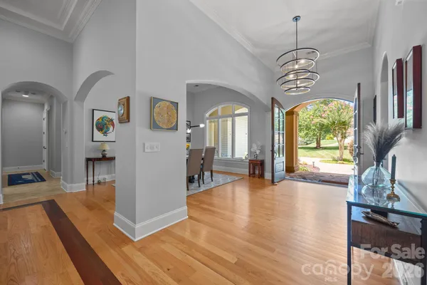 a view of a hallway with wooden floor and windows