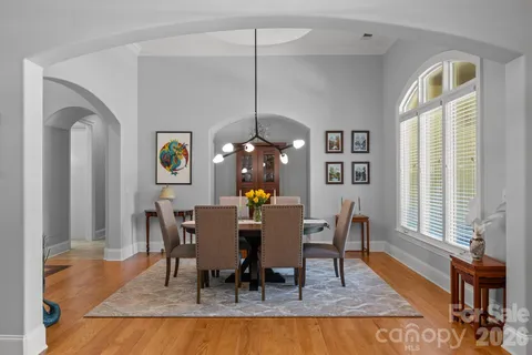 a dining room with wooden floor and a rug