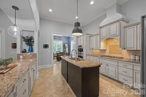 a kitchen with granite countertop a stove sink and cabinets