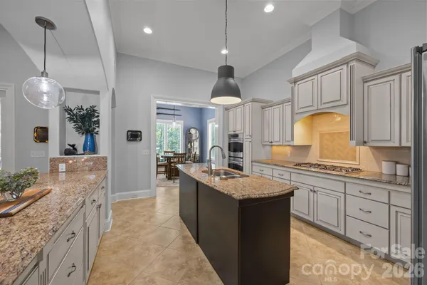 a large kitchen with kitchen island a sink stainless steel appliances and cabinets
