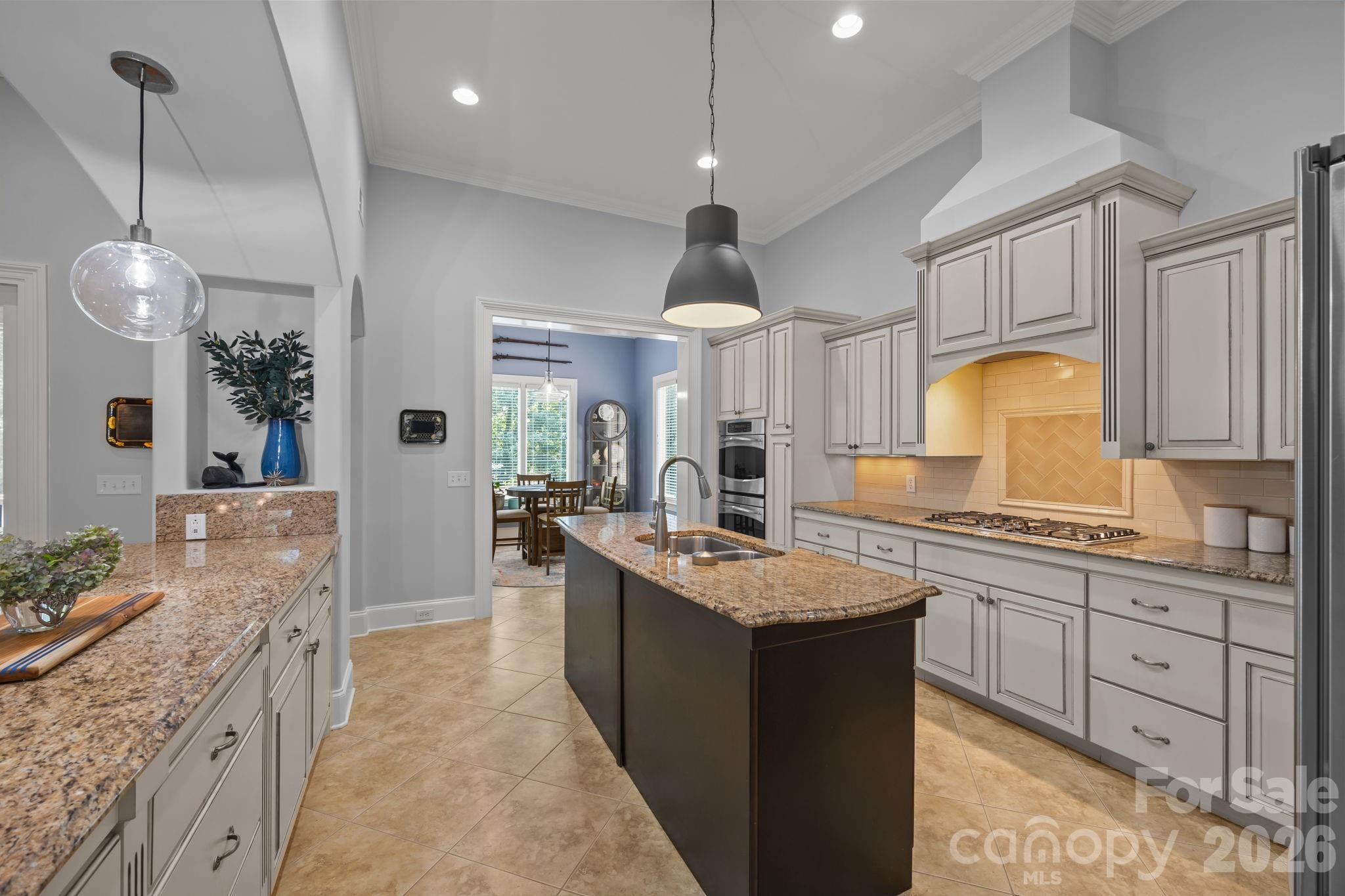 242 Anniston Way Davidson, NC 28036 - Photo 16 of 42 a large kitchen with kitchen island a sink stainless steel appliances and cabinets