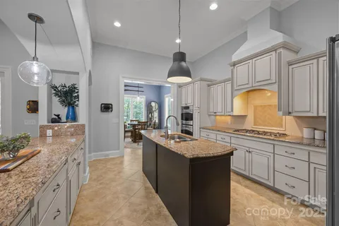 a large kitchen with kitchen island a sink stainless steel appliances and cabinets