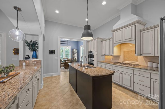 a large kitchen with kitchen island a sink stainless steel appliances and cabinets