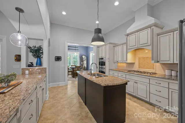 a large kitchen with kitchen island a sink stainless steel appliances and cabinets