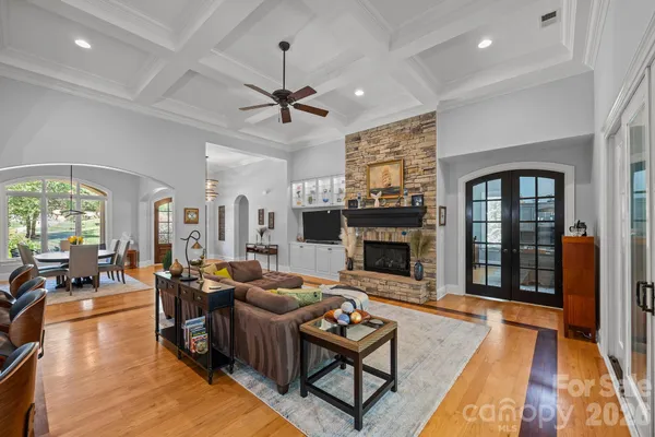 a living room with furniture a fireplace and a chandelier