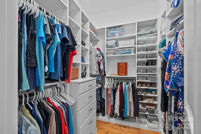 a view of walk in closet with clothes and shoes