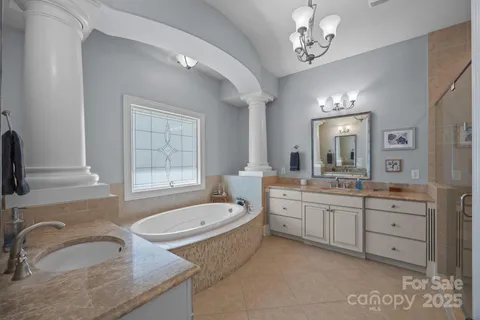 a bathroom with a granite countertop sink mirror and bathtub