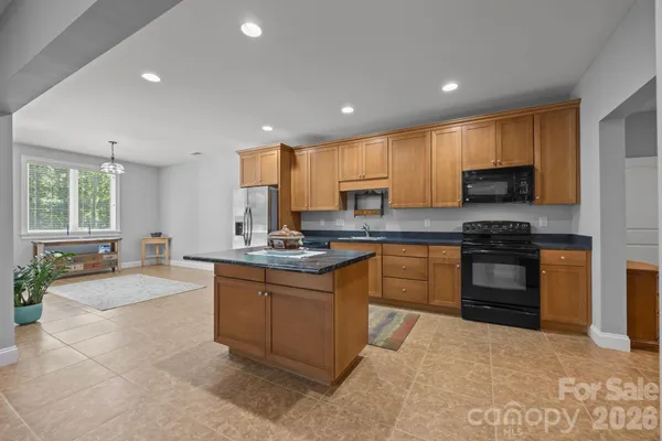 a kitchen with granite countertop a stove sink and cabinets