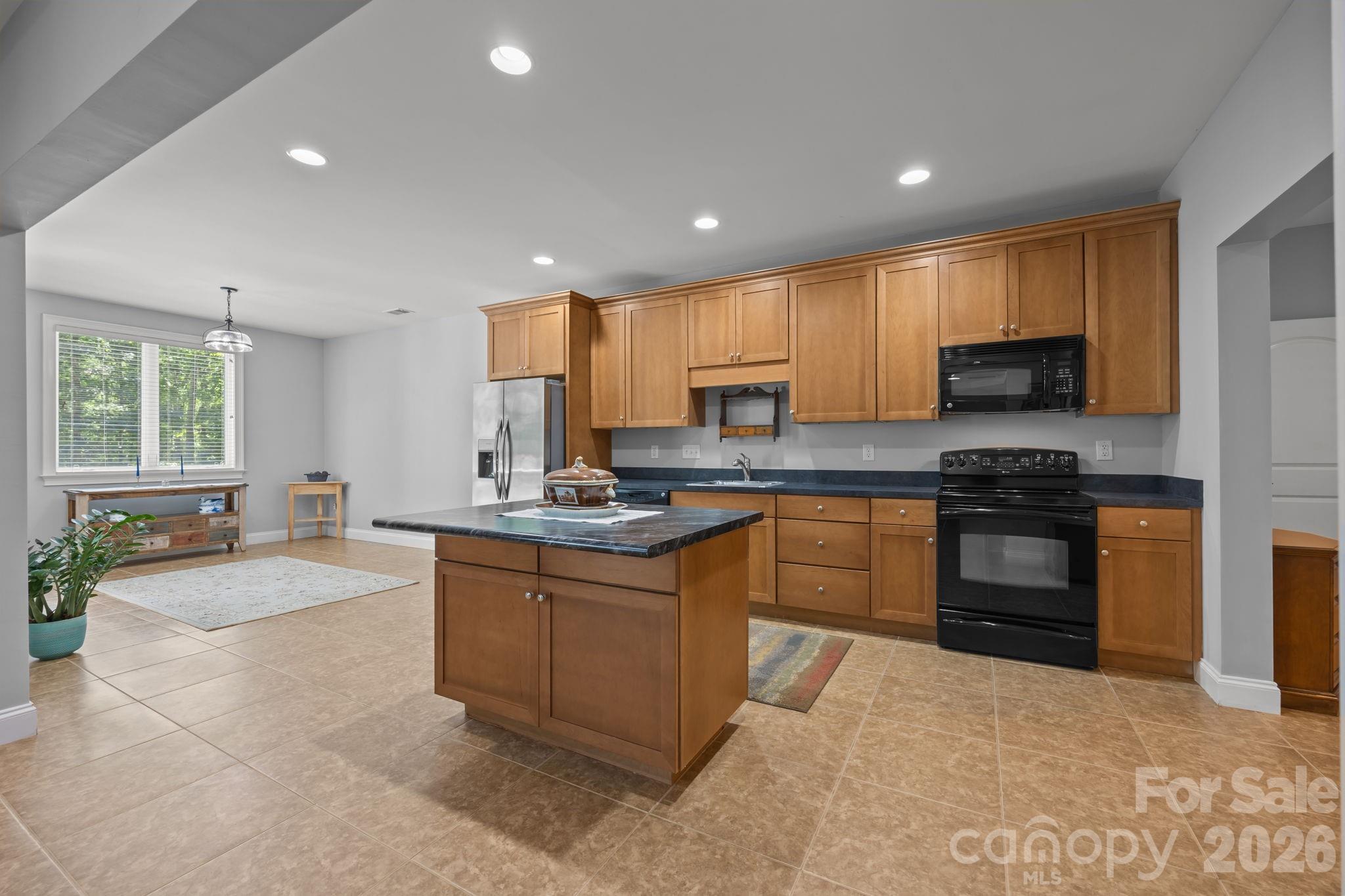 242 Anniston Way Davidson, NC 28036 - Photo 26 of 42 a kitchen with granite countertop a stove sink and cabinets