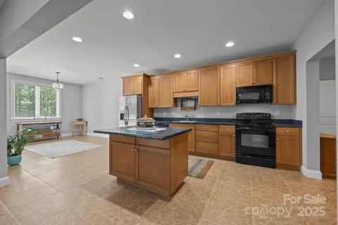 a kitchen with granite countertop a stove sink and cabinets