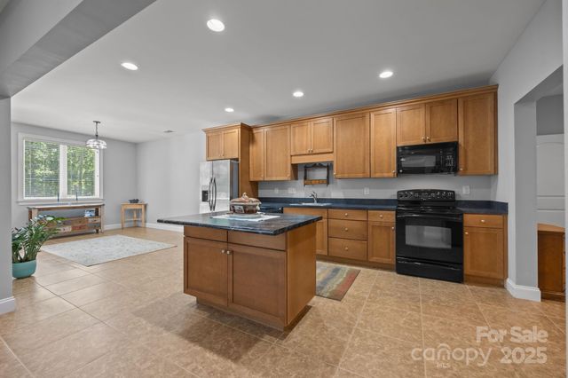 a kitchen with granite countertop a stove sink and cabinets