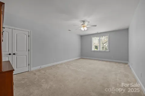 an empty room with windows and ceiling fan