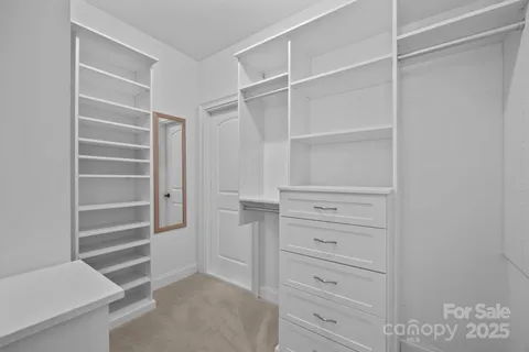 a view of walk in closet with empty racks