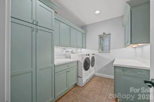 a utility room with cabinets washer and dryer