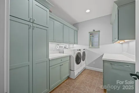 a utility room with cabinets washer and dryer