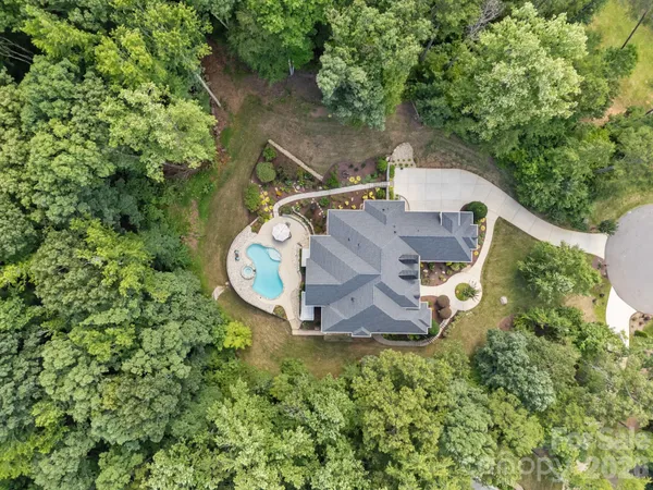a front view of a house with garden and trees