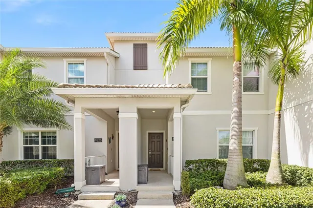 a front view of a house with a lots of windows and plants