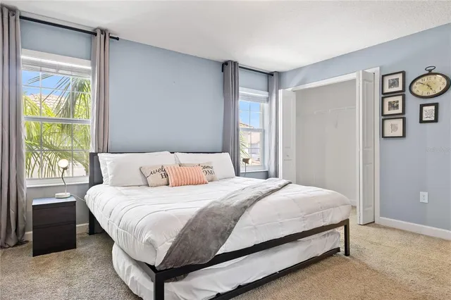 a bedroom with a bed lamp and a large window