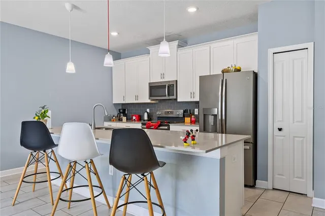 a kitchen with stainless steel appliances granite countertop white cabinets a refrigerator and a stove