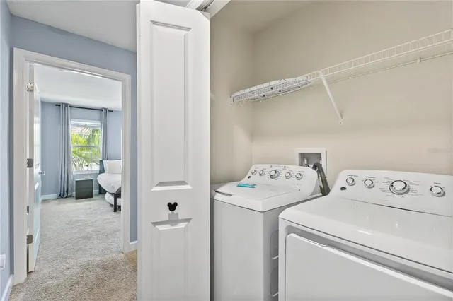 a view of washer and dryer with bathroom in the background