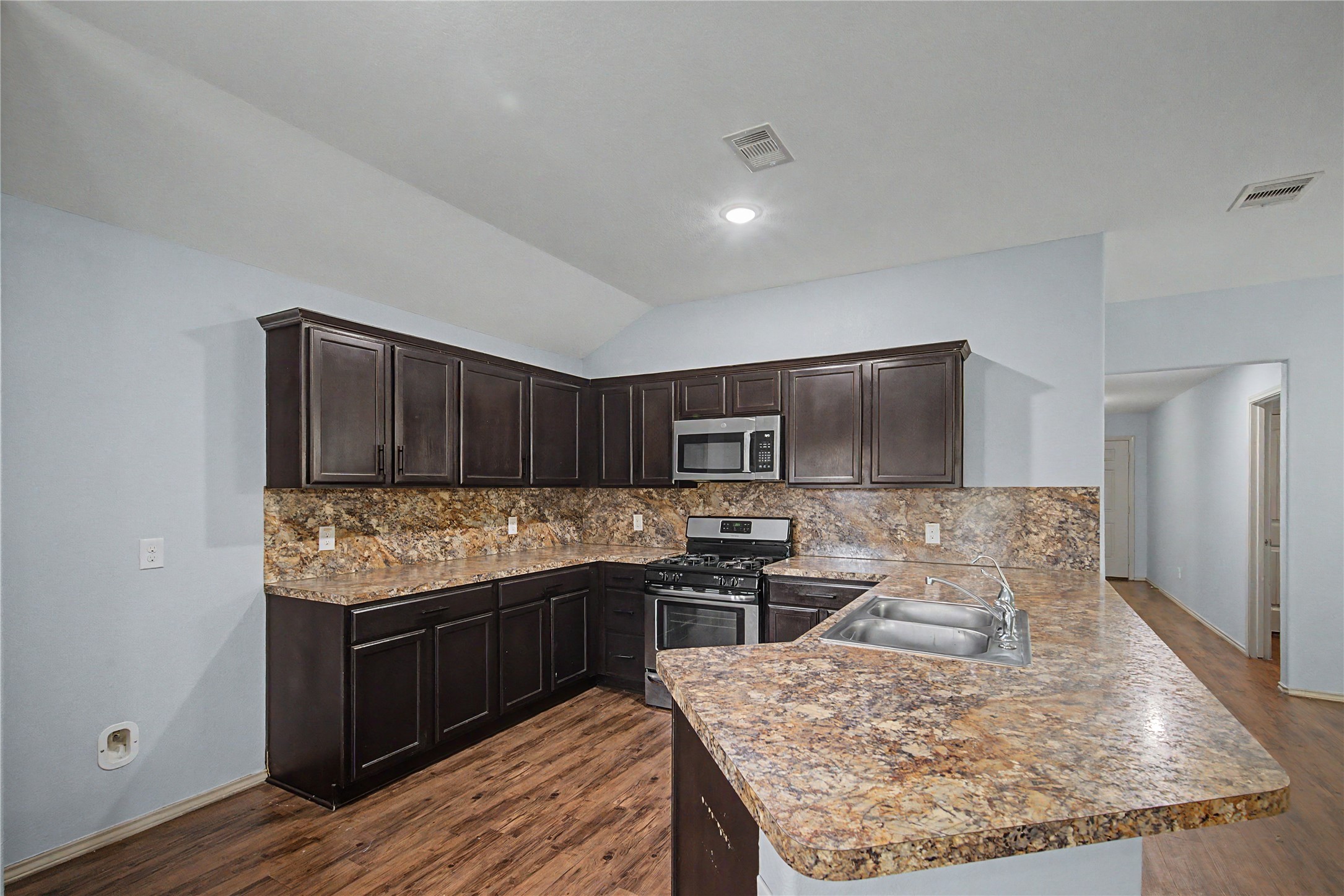 16430 Rodeo River Road Houston, TX 77049 - Photo 23 of 34 a kitchen with kitchen island granite countertop a sink stove and refrigerator