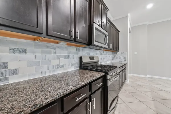 a kitchen with stainless steel appliances granite countertop a sink stove and cabinets