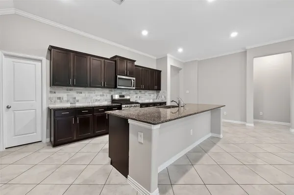 a kitchen with stainless steel appliances granite countertop a stove a sink and a refrigerator