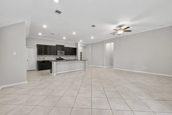 a view of a kitchen with a sink and an empty room