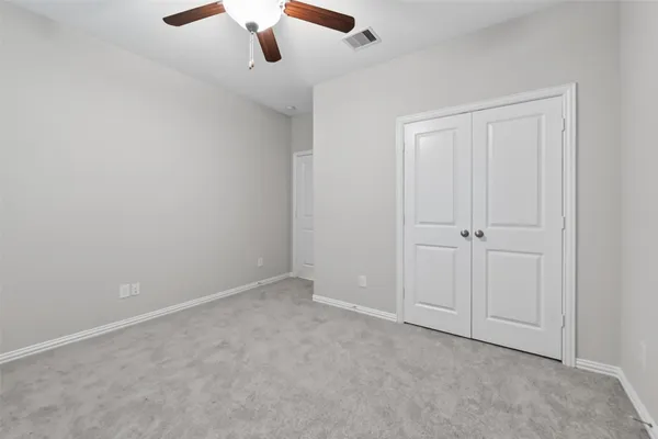 an empty room with chandelier fan