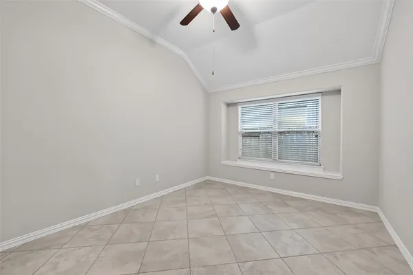 an empty room with chandelier fan and windows