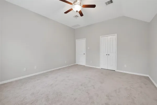 an empty room with chandelier fan