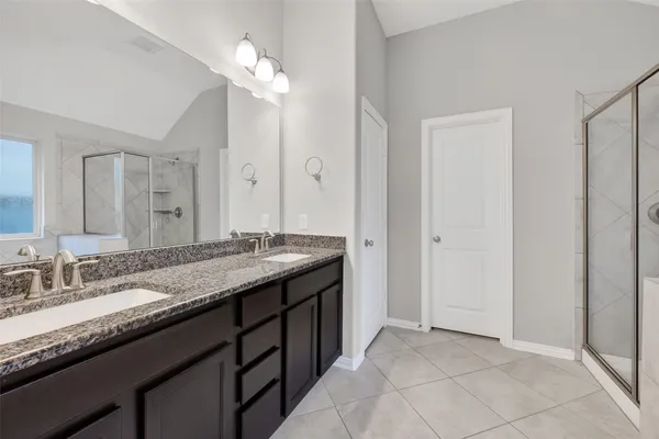 a bathroom with a granite countertop sink a light fixture and a mirror