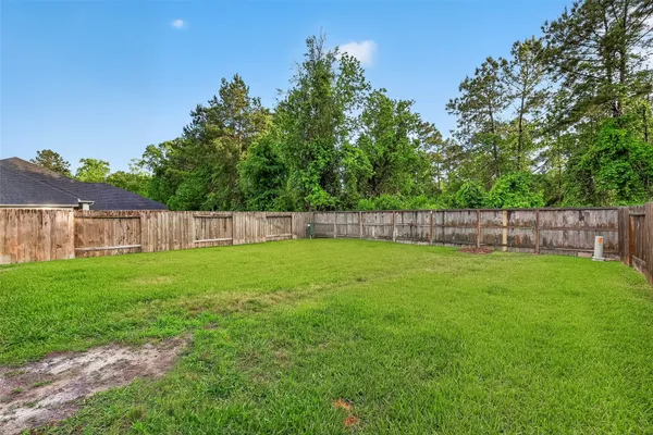 a view of a yard with wooden fence