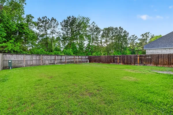 a view of yard with trees in the background