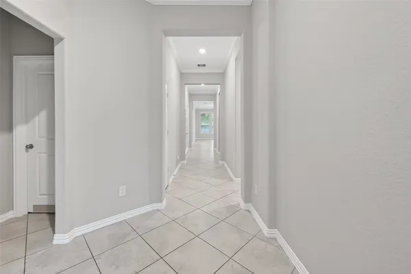 a view of a hallway with wooden floor and a bathroom
