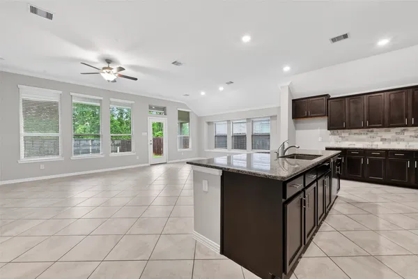 a kitchen with granite countertop a stove sink and cabinets