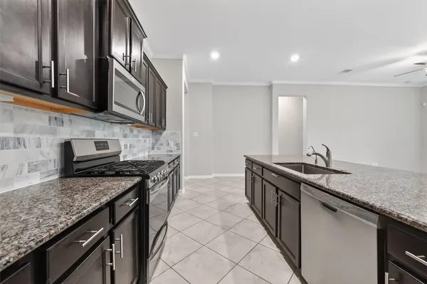 a kitchen with stainless steel appliances granite countertop a sink stove and cabinets