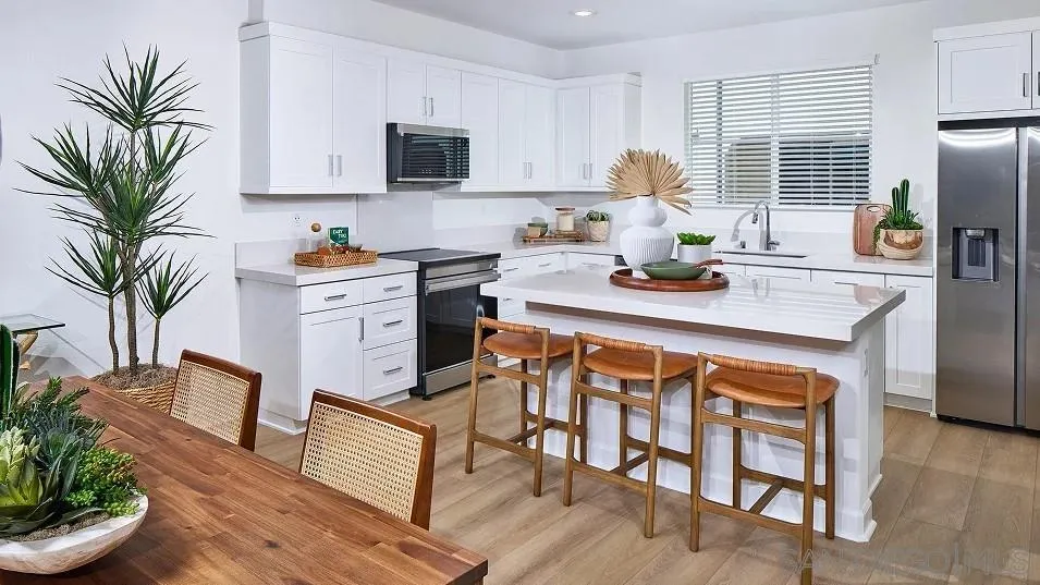 1810 Mountain Laurel Road San Marcos, CA 92078 - Photo 3 of 14 a kitchen with stainless steel appliances a dining table a stove a microwave a refrigerator and cabinets